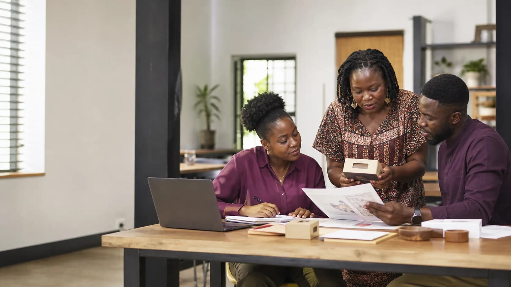 Three people in Accra working together on study, business and community materials
